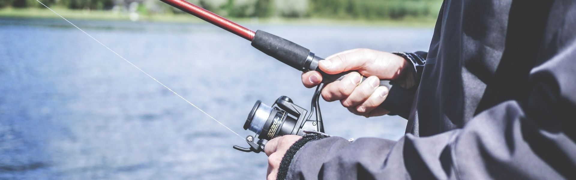 Hands reeling in a fishing rod