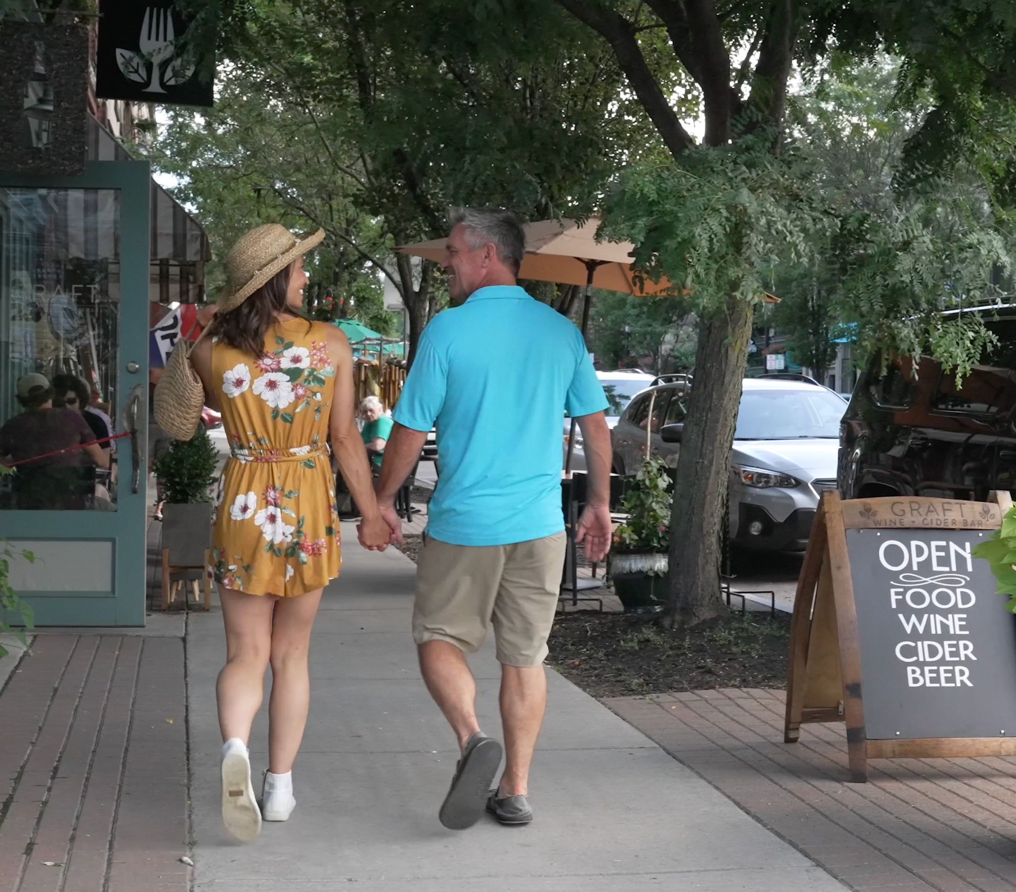 A couple walking past shops and restaurants in downtown Watkins Glen
