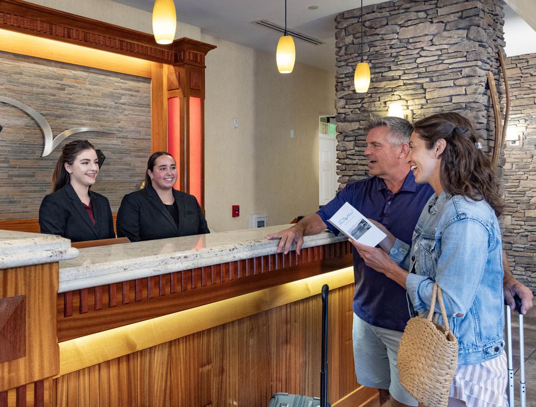 Two guests checking in at the front desk of the Watkins Glen Harbor Hotel
