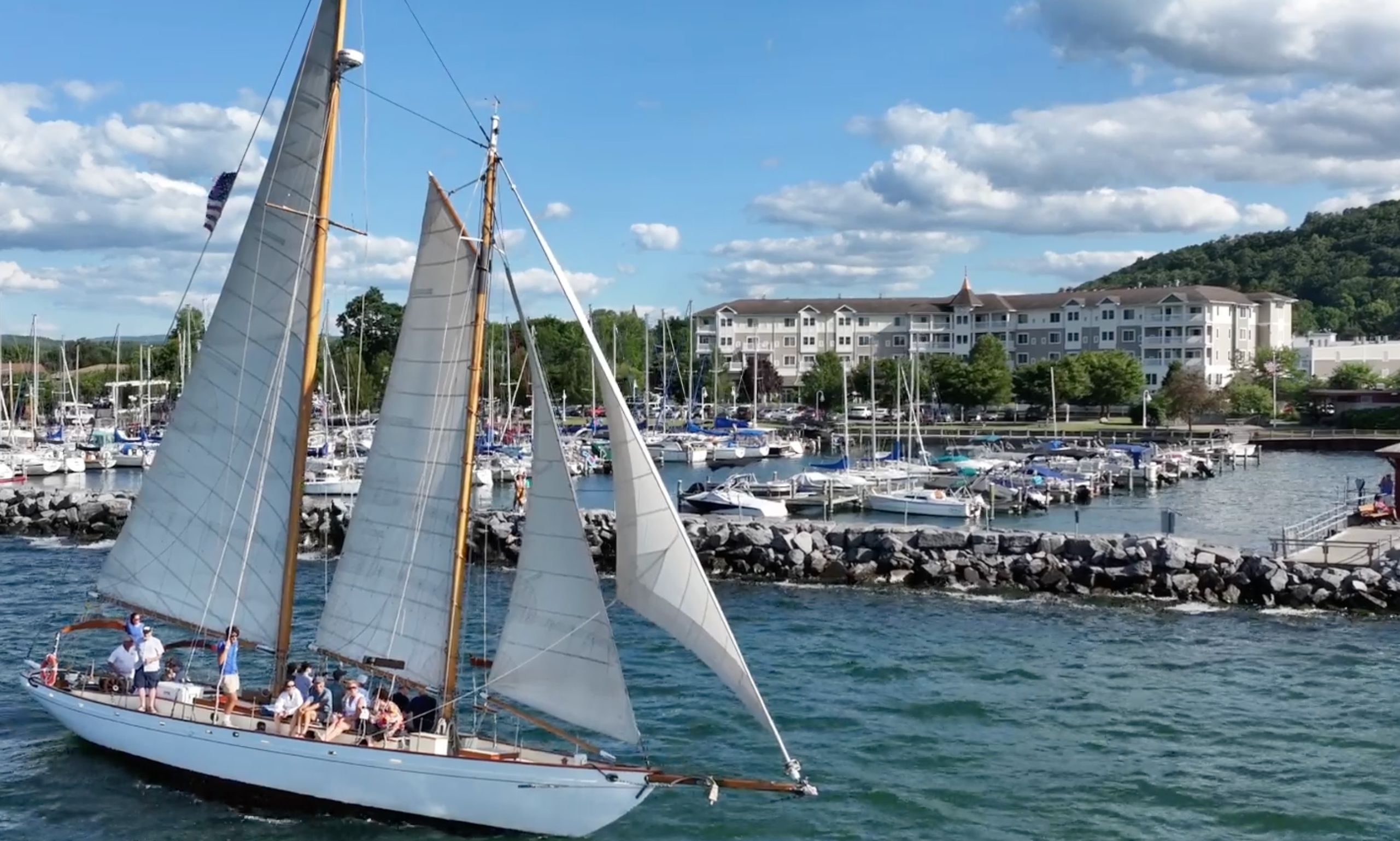 A schooner crossing is front of the marina in front of the Watkins Glen Harbor Hotel