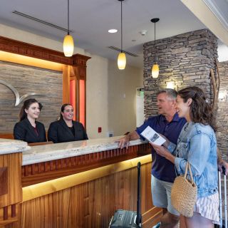 Two guests checking in at the front desk of the Watkins Glen Harbor Hotel