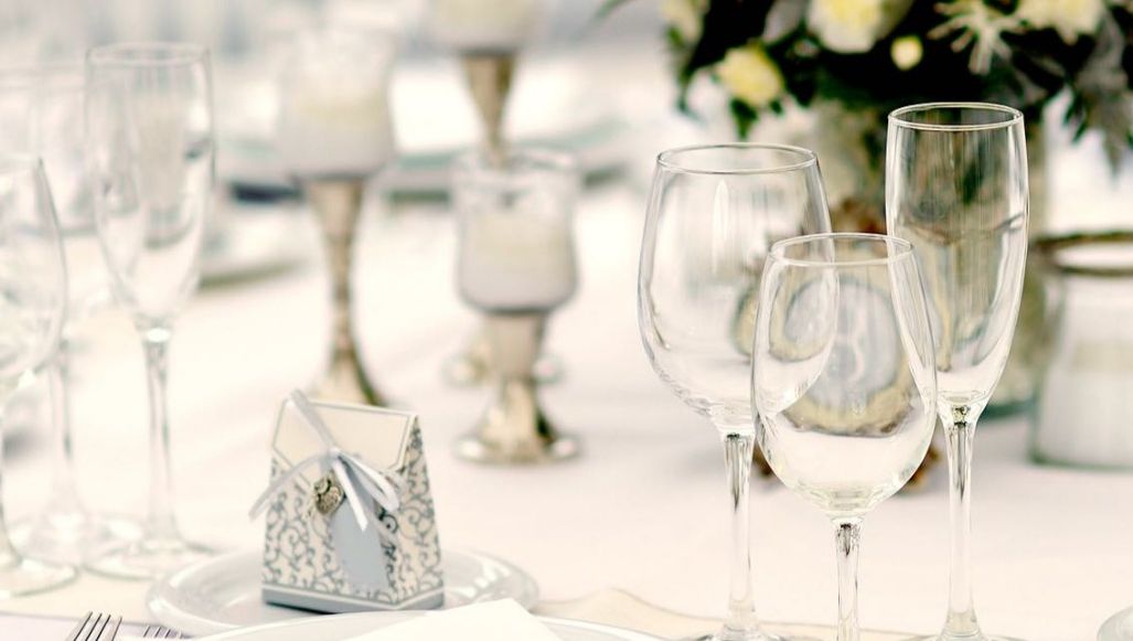 An elegant table setting featuring white china and several wine glasses and flutes
