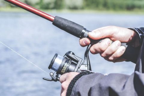 Hands reeling in a fishing rod