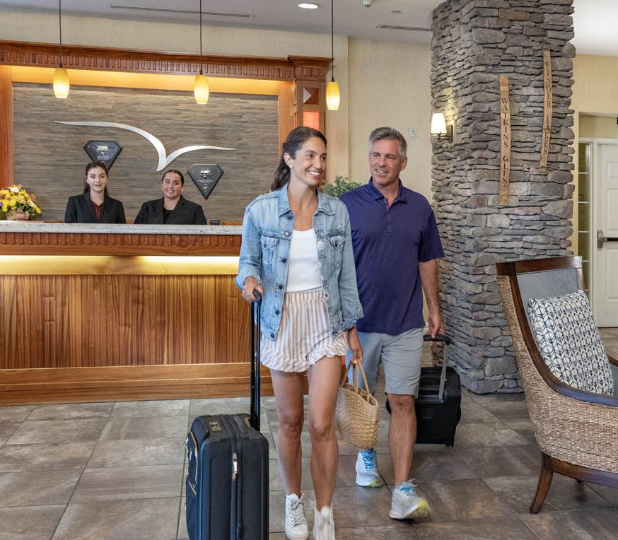 A couple heading up to their room with their bags after leaving the check-in desk